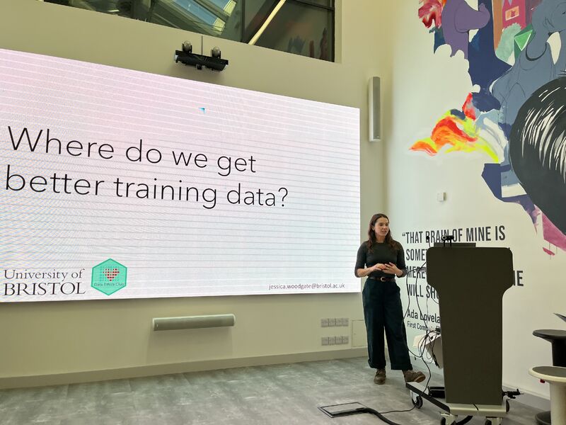 A person standing in front of a whiteboard with the text "Where do we get better training data"?